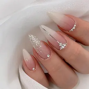 Pink ombré almond nails with glitter and crystal accents